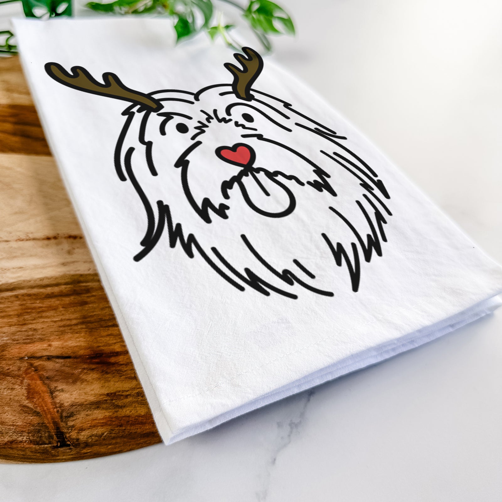 Minimalist line drawing of Tucker the Bearded Collie with reindeer antlers and a red nose on a tea towel