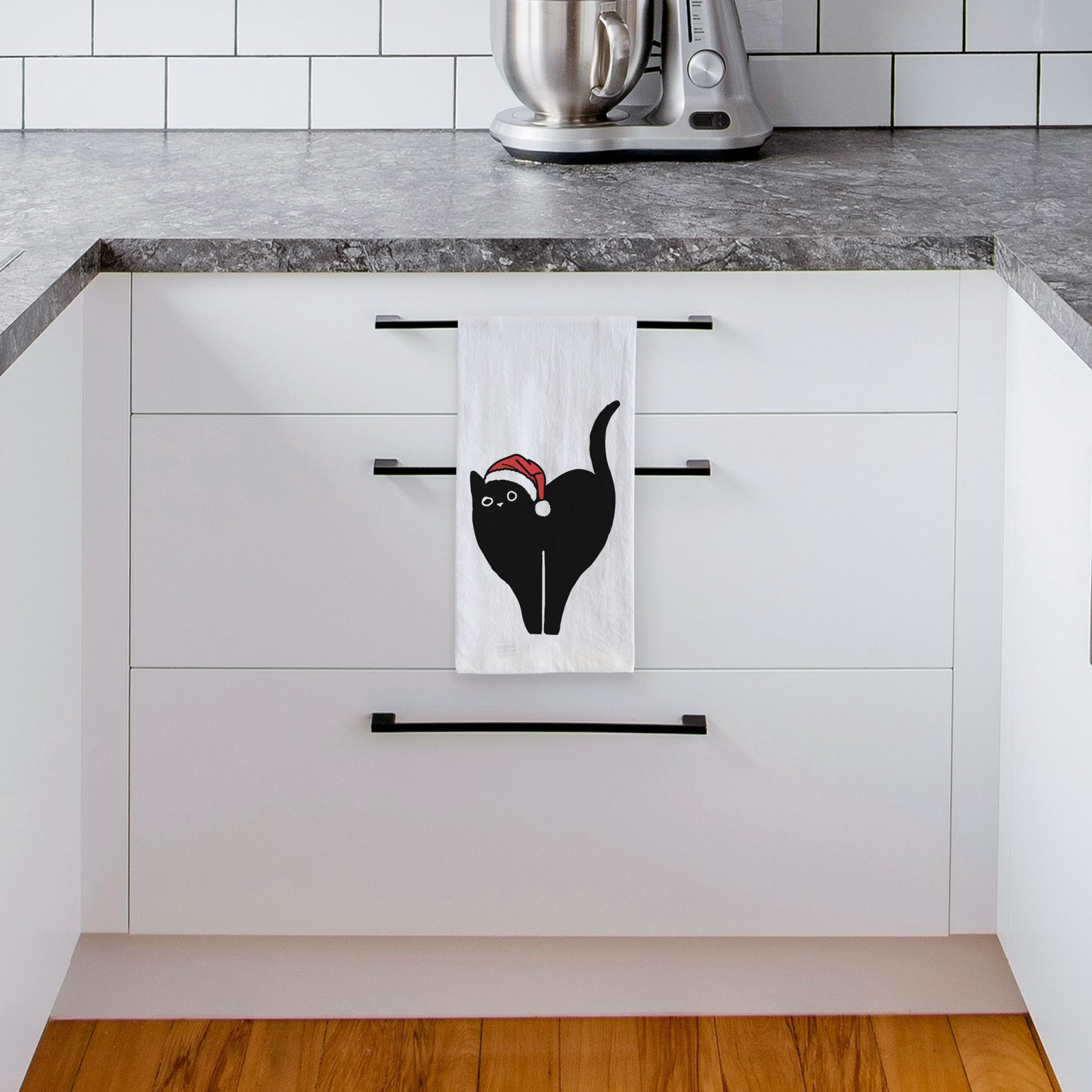 Minimalist line drawing of Bella the Black Cat wearing a Santa hat on a tea towel, hanging on an oven door in a kitchen