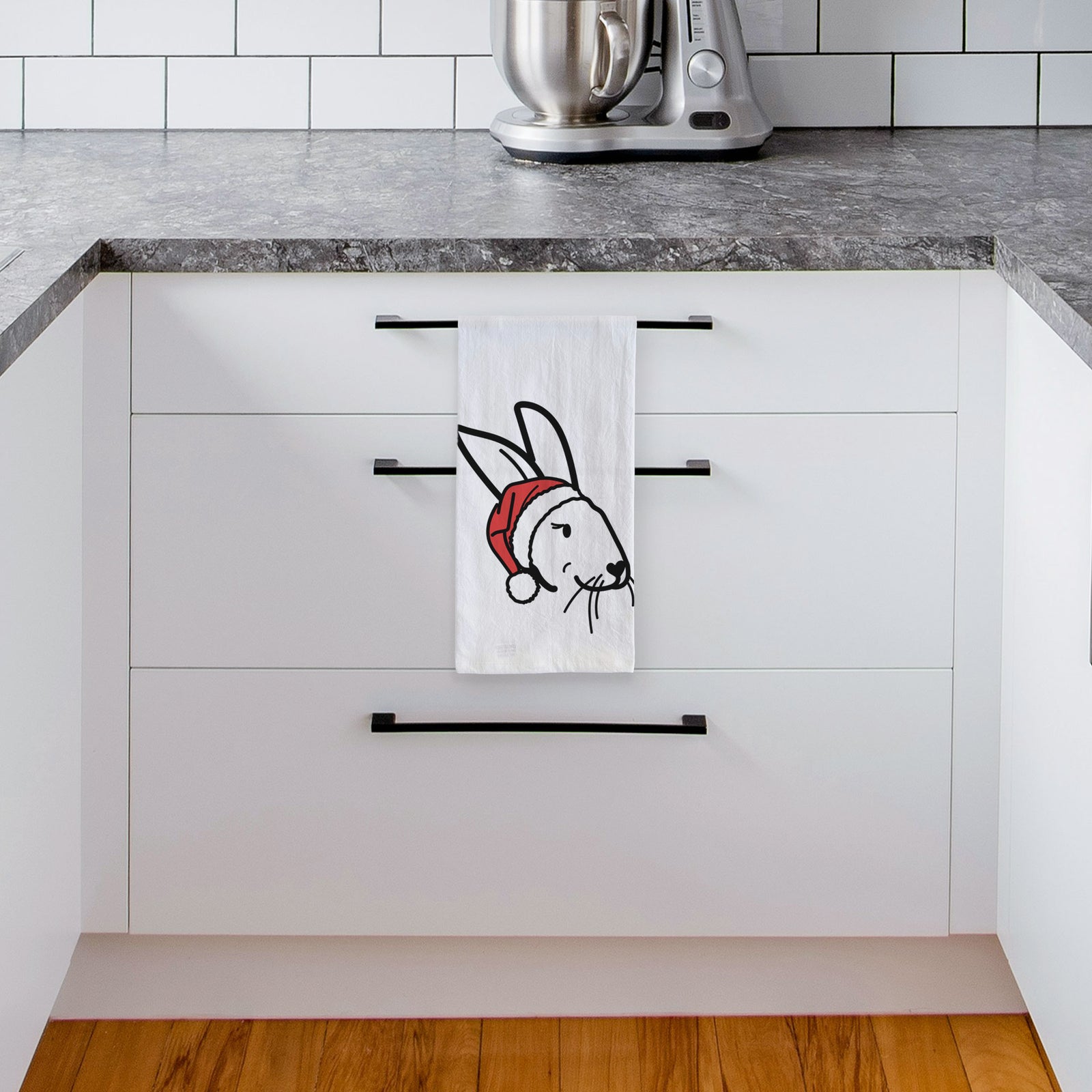 Minimalist line drawing of Betsy the Rex Rabbit wearing a Santa hat on a tea towel, hanging on an oven door in a kitchen