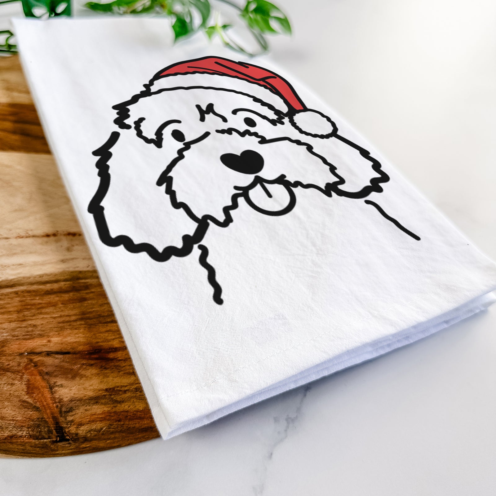 Minimalist line drawing of a Cavapoo wearing a Santa hat on a tea towel