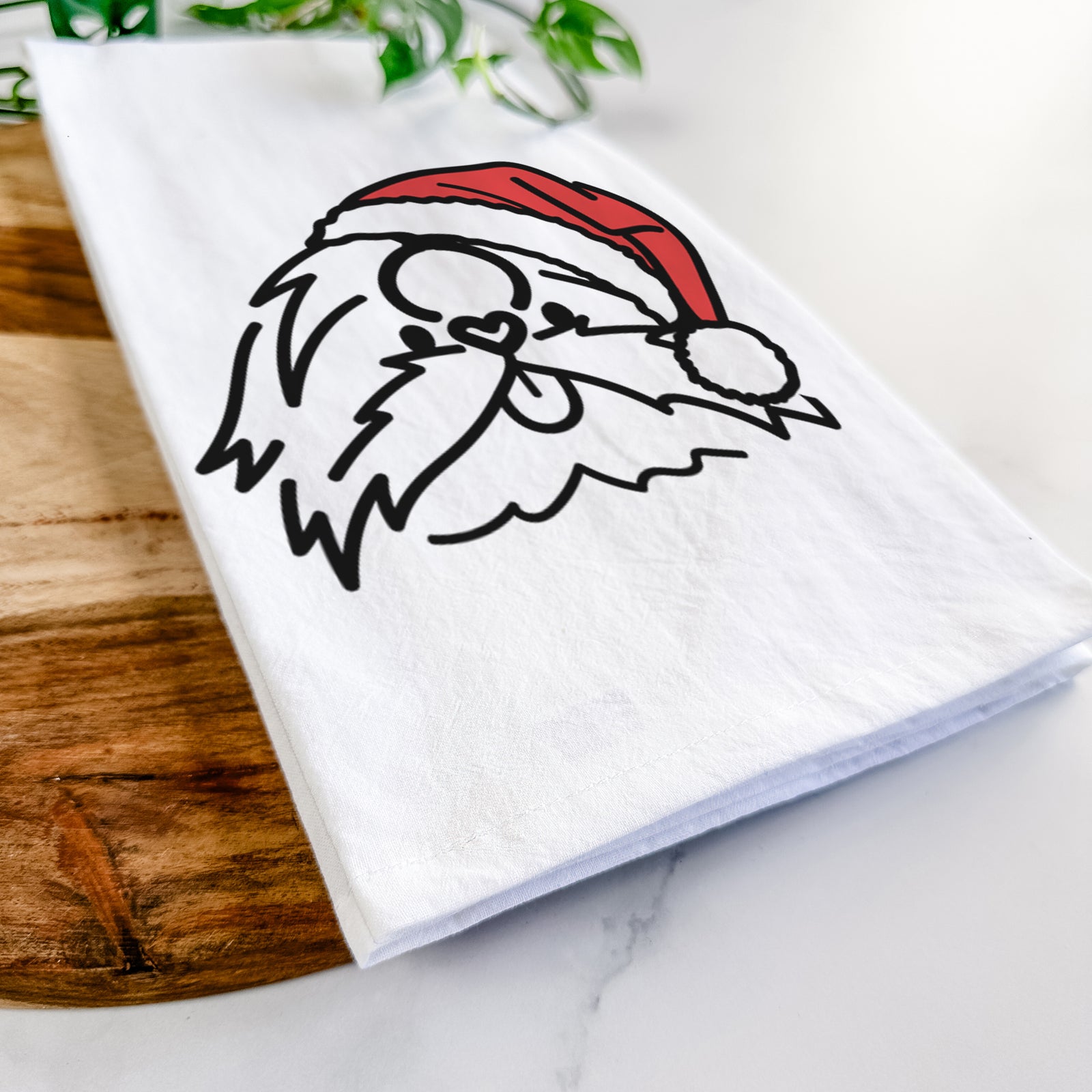Minimalist line drawing of CoCo the Shih Tzu wearing a Santa hat on a tea towel