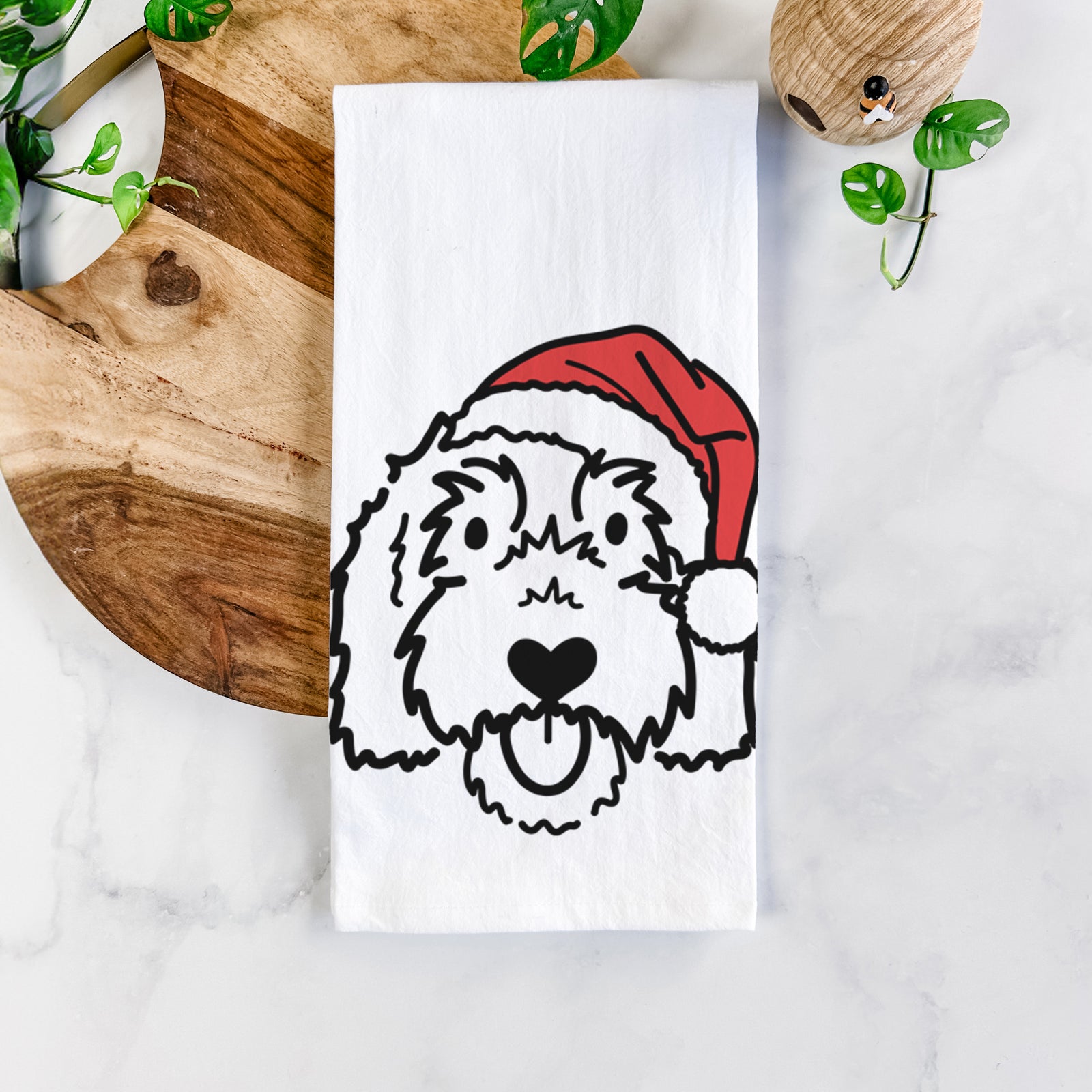 Minimalist line drawing of Gus the Goldendoodle wearing a Santa hat on a tea towel