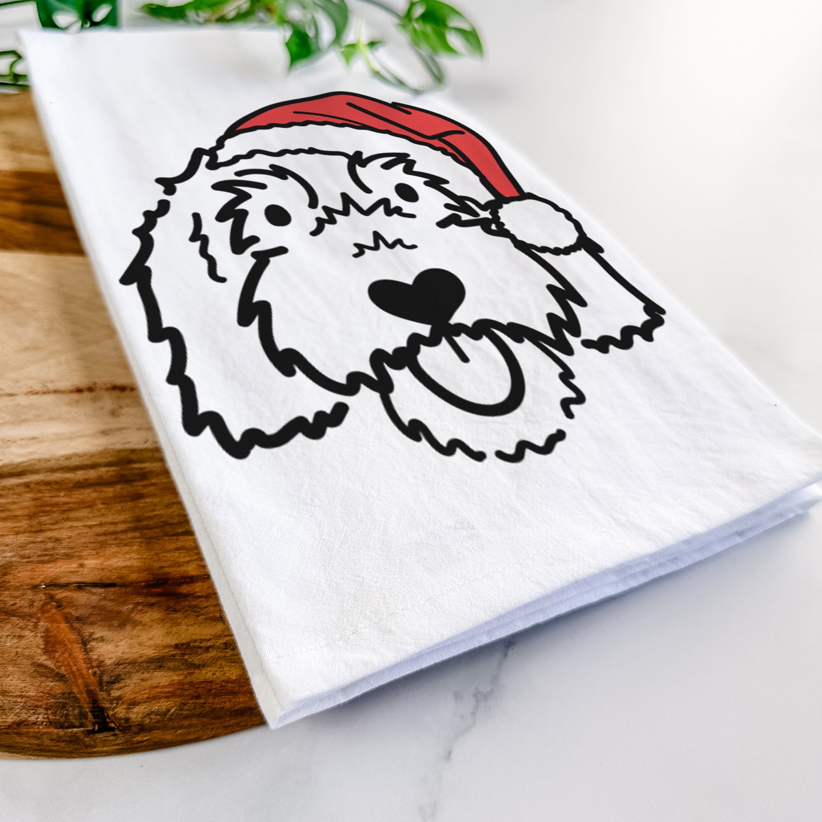 Minimalist line drawing of Gus the Goldendoodle wearing a Santa hat on a tea towel