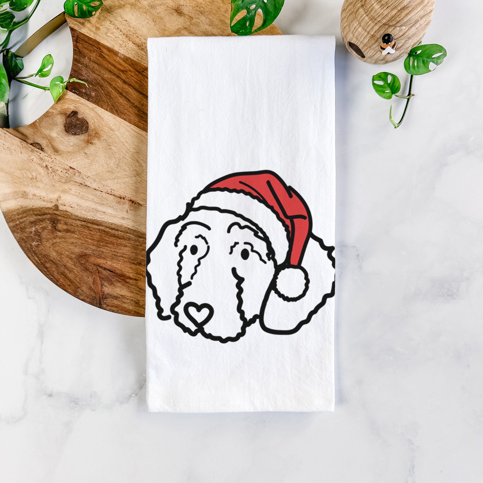 Minimalist line drawing of Hanna the Goldendoodle wearing a Santa hat on a tea towel