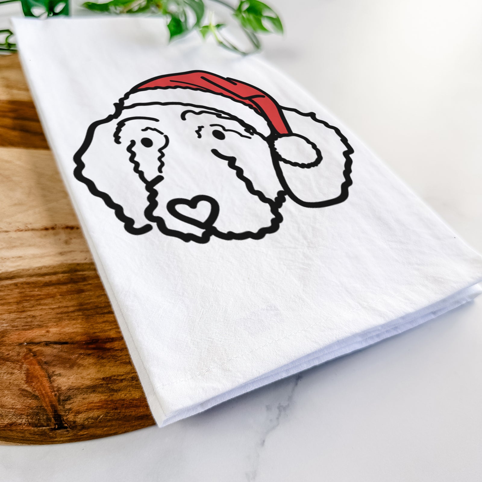 Minimalist line drawing of Hanna the Goldendoodle wearing a Santa hat on a tea towel