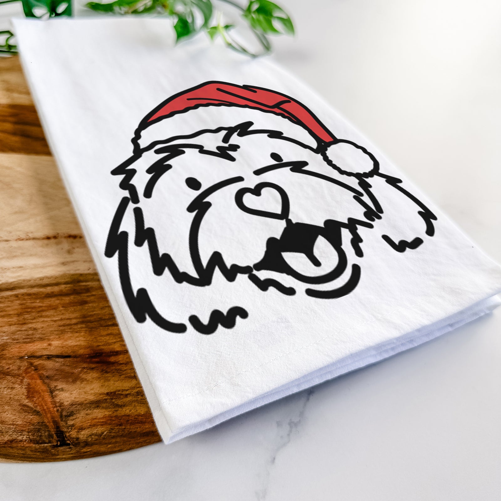 Minimalist line drawing of Harry the Cavachon wearing a Santa hat on a tea towel