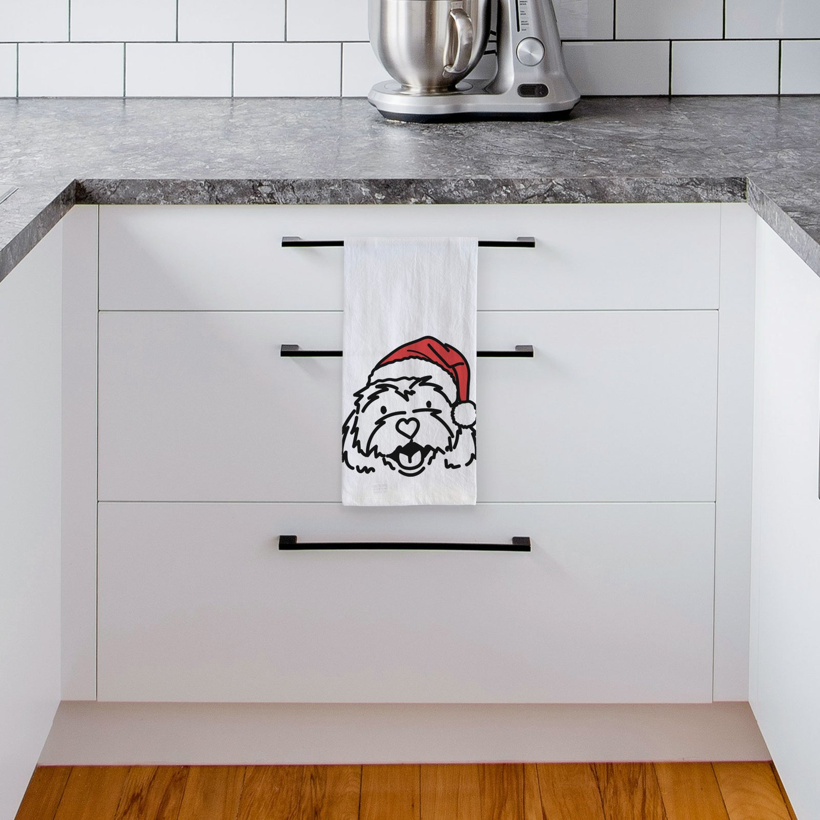 Minimalist line drawing of Harry the Cavachon wearing a Santa hat on a tea towel, hanging on an oven door in a kitchen