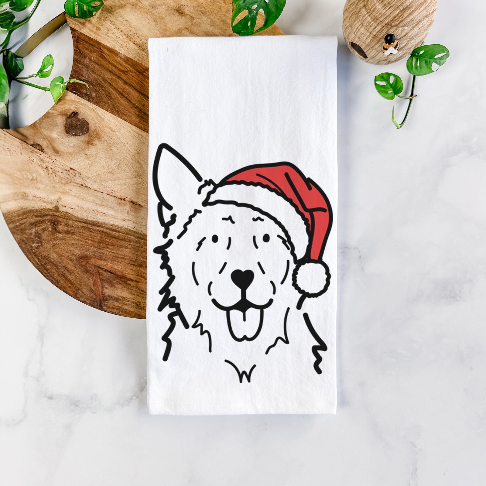 Minimalist line drawing of Jack the Mudi wearing a Santa hat on a tea towel