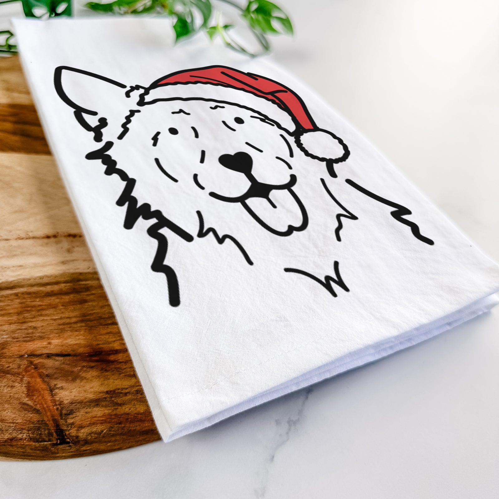 Minimalist line drawing of Jack the Mudi wearing a Santa hat on a tea towel