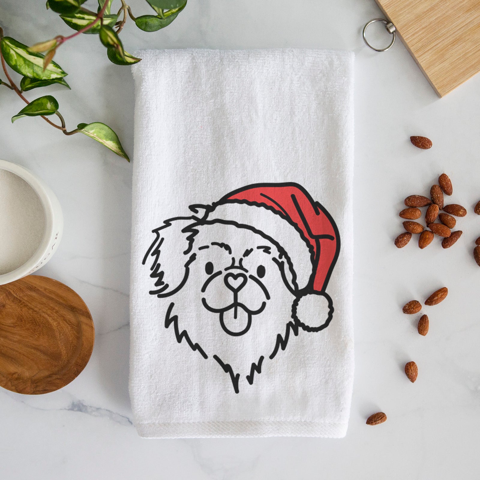 Minimalist line drawing of Jiji the Tibetan Spaniel wearing a Santa hat on a decorative hand towel