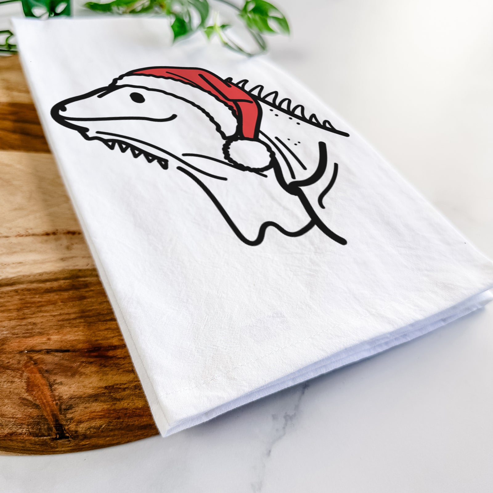 Minimalist line drawing of Louie the Iguana wearing a Santa hat on a tea towel