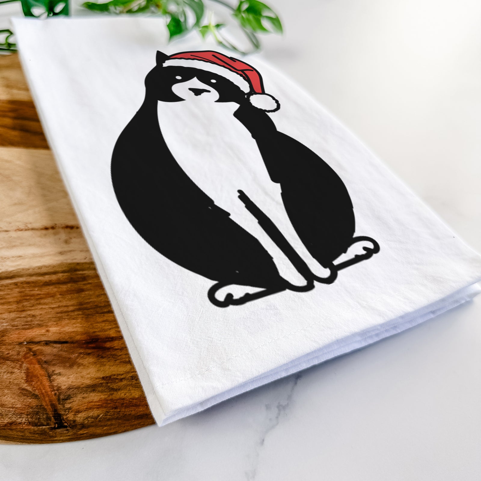 Minimalist line drawing of Oliver the Tuxedo Cat wearing a Santa hat on a tea towel