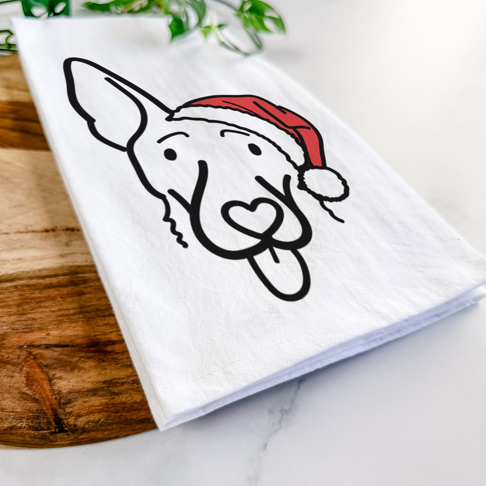 Minimalist line drawing of Rosie the Shepherd Mix wearing a Santa hat on a tea towel