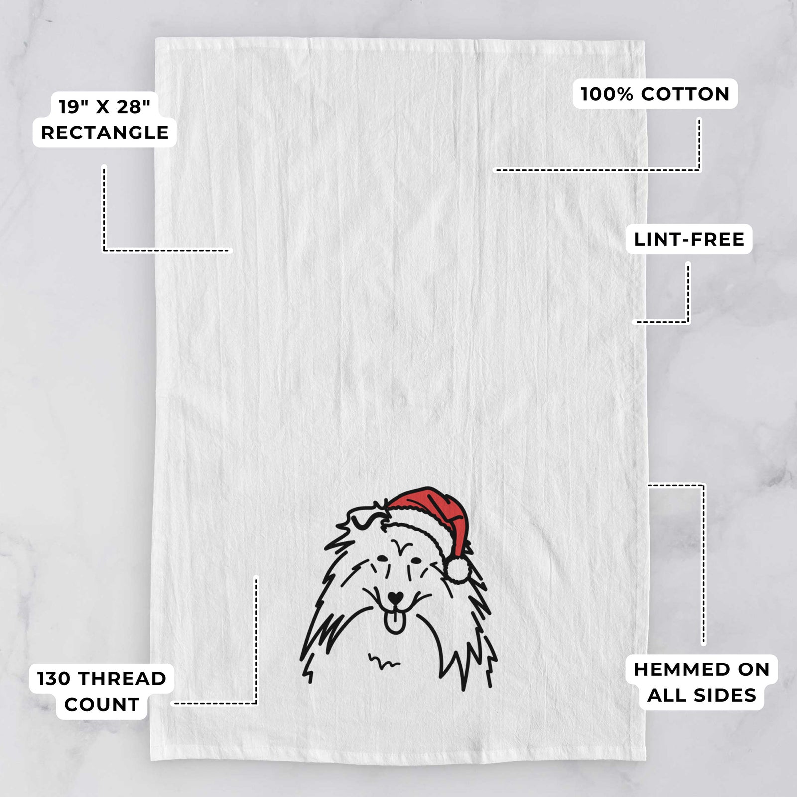 Minimalist line drawing of a Rough Collie wearing a Santa hat on a tea towel, with feature callouts: 19 x 28 inch rectangle, 100% cotton, lint-free, 120 thread count, hemmed on all sides