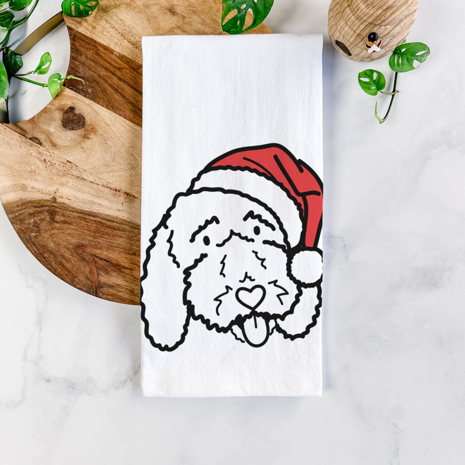 Minimalist line drawing of Ruby the Bernedoodle wearing a Santa hat on a tea towel