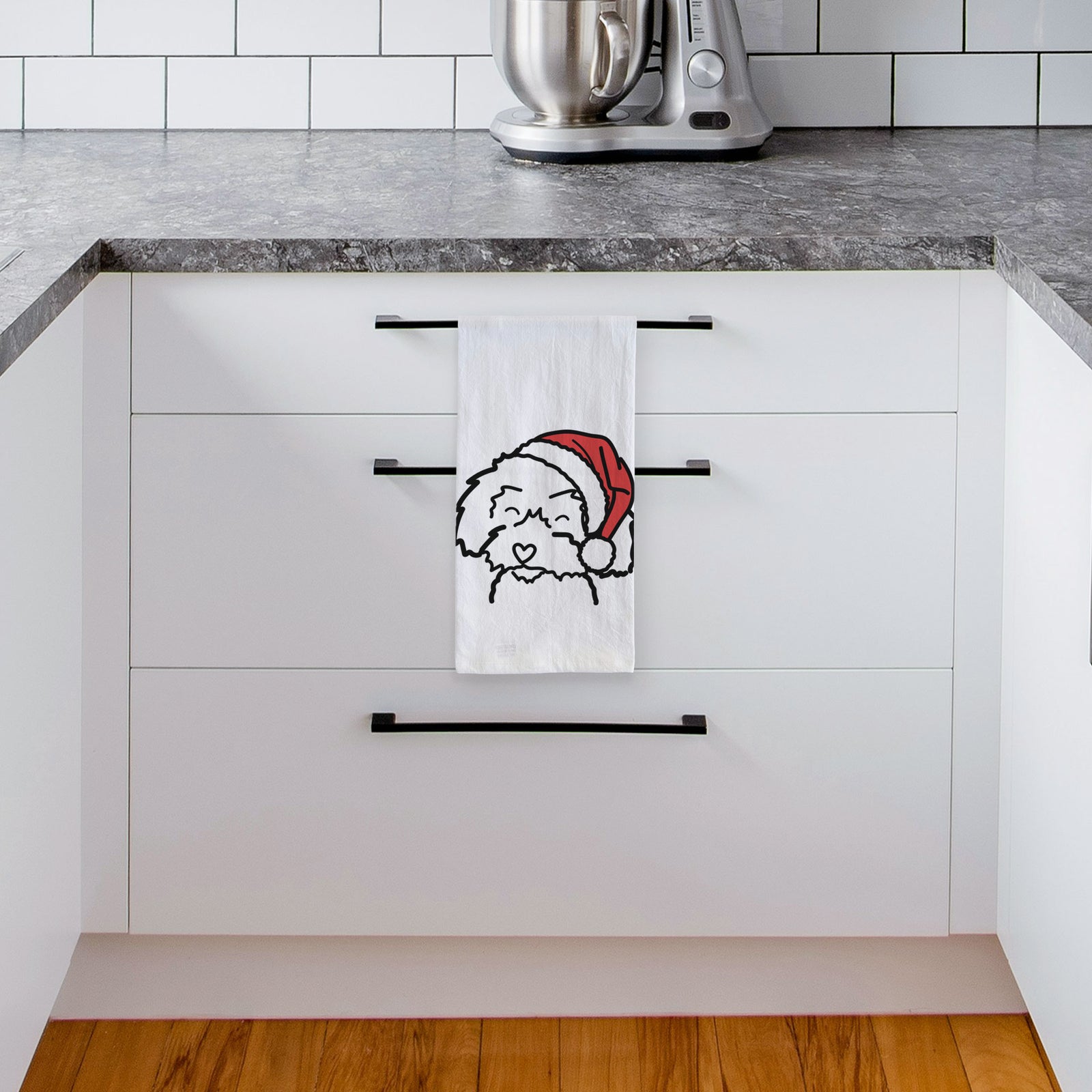 Minimalist line drawing of a Schnoodle wearing a Santa hat on a tea towel, hanging on an oven door in a kitchen