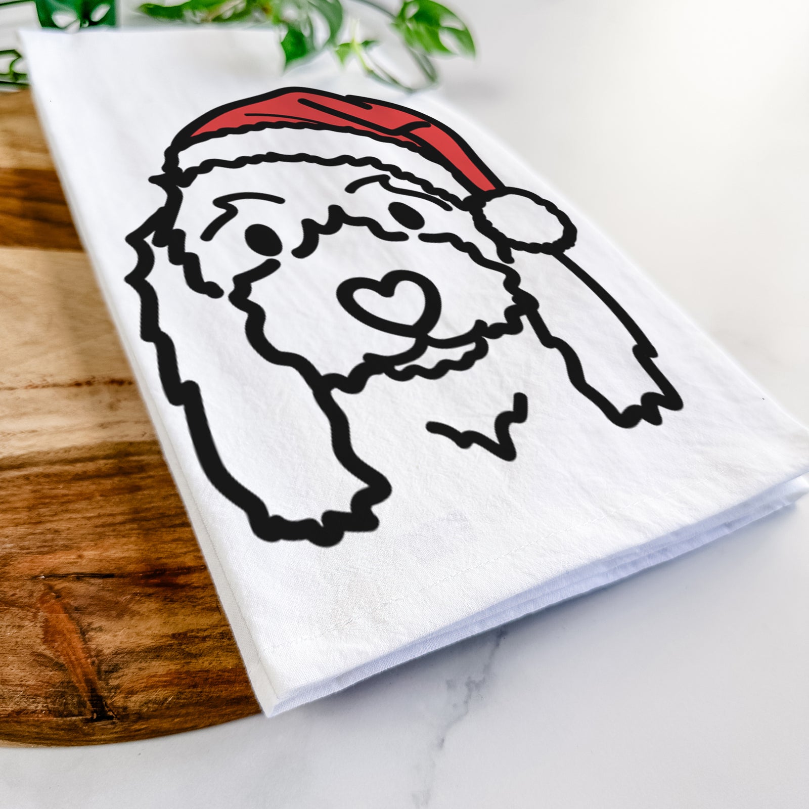 Minimalist line drawing of Sophie the Coton de Tulear wearing a Santa hat on a tea towel