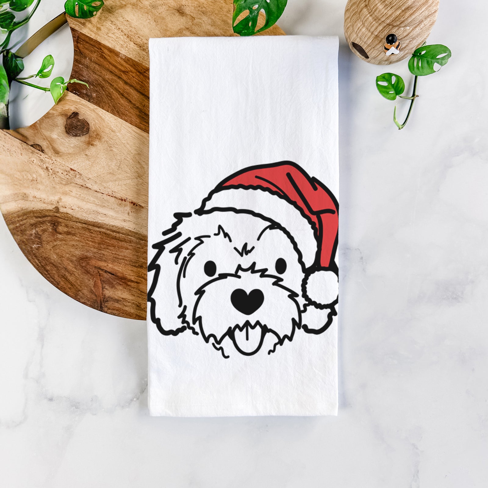 Minimalist line drawing of Sprinkles the Cockapoo wearing a Santa hat on a tea towel