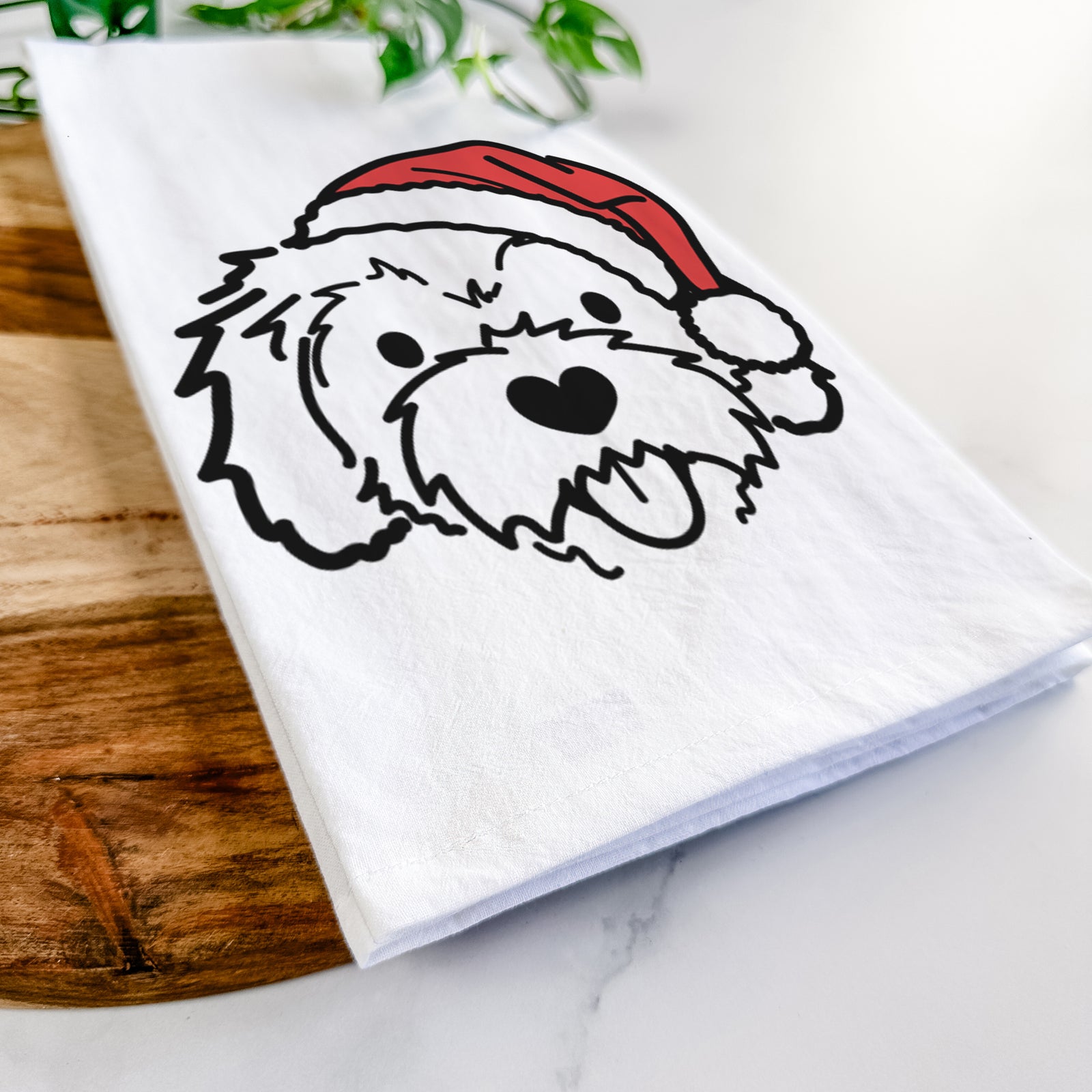 Minimalist line drawing of Sprinkles the Cockapoo wearing a Santa hat on a tea towel