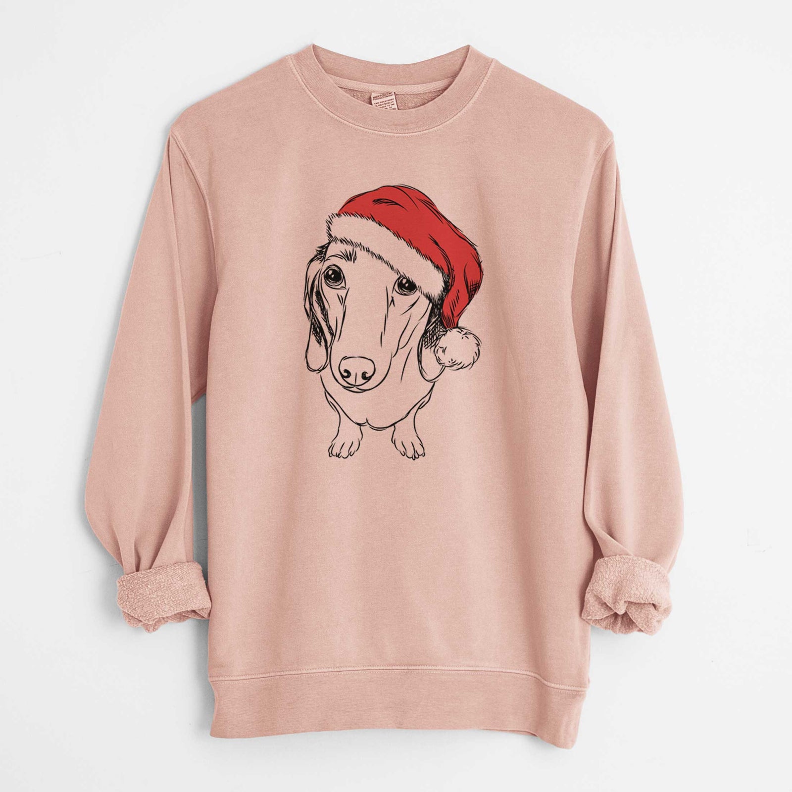 Hand-drawn sketch of Annabelle the Dachshund wearing a Santa hat on a Dusty Pink Unisex pigment dyed crew sweatshirt