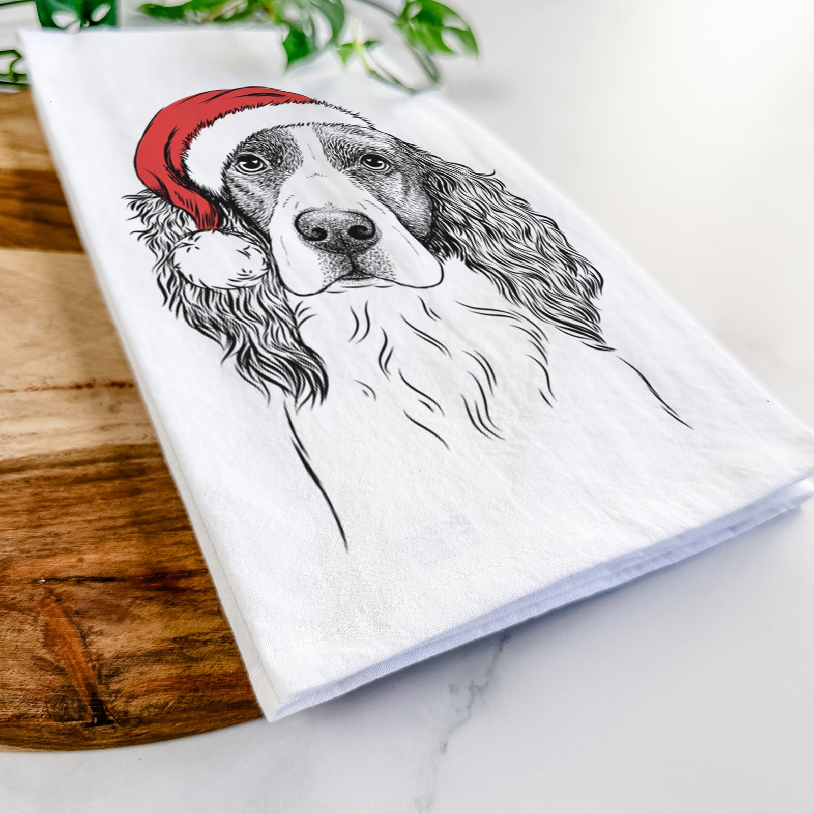 Hand-drawn sketch of Annie the English Springer Spaniel wearing a Santa hat on a tea towel