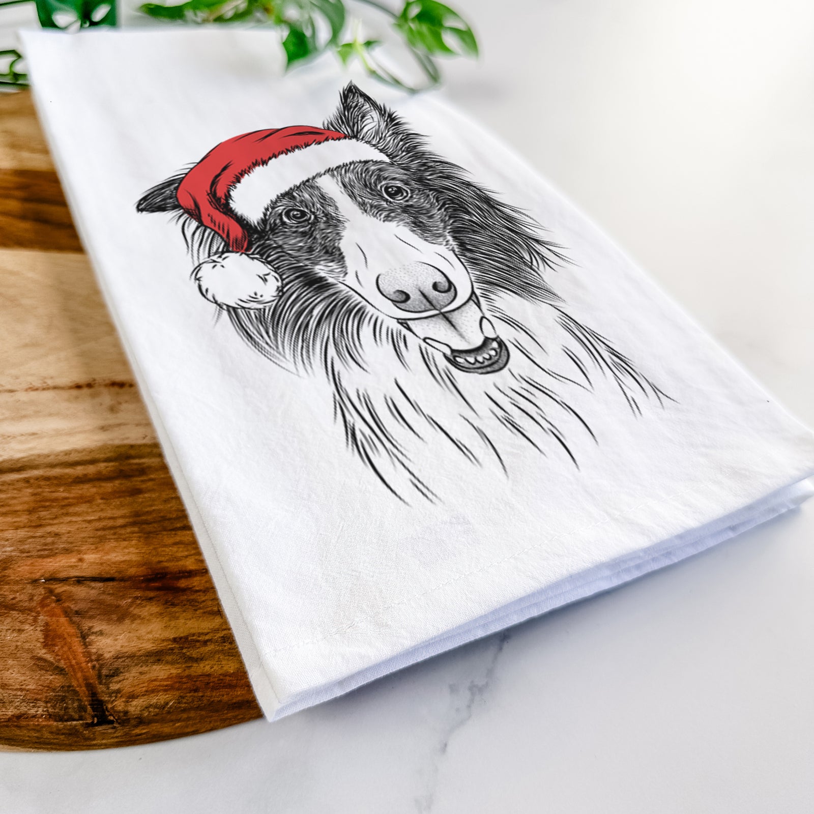 Hand-drawn sketch of Archie the Silken Windhound wearing a Santa hat on a tea towel