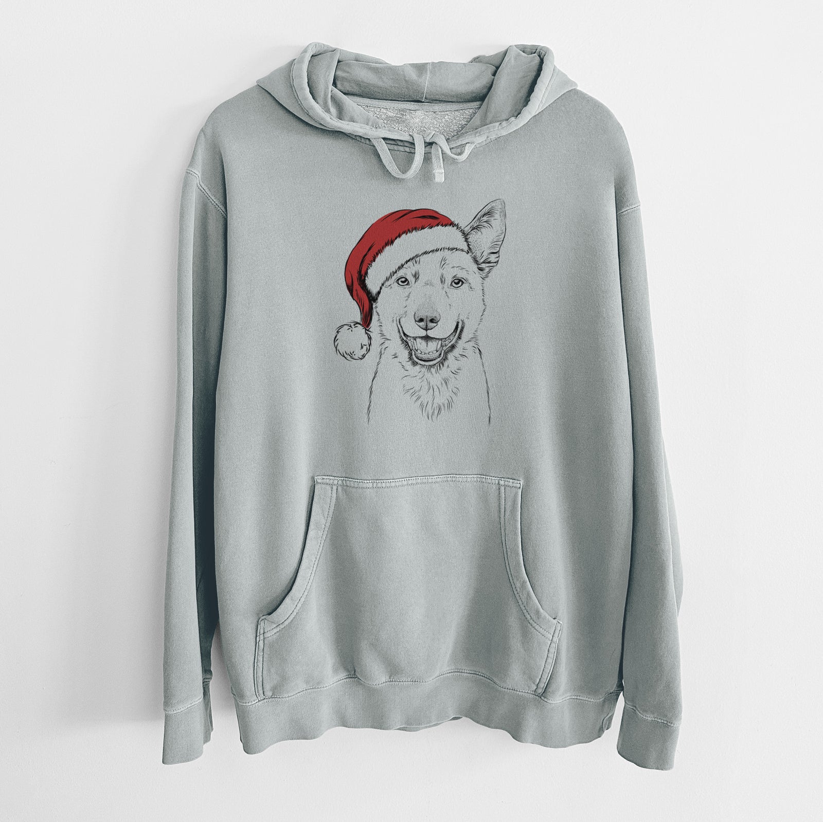 Hand-drawn sketch of Arden the Australian Kelpie wearing a Santa hat on a Sage Unisex pigment dyed hoodie