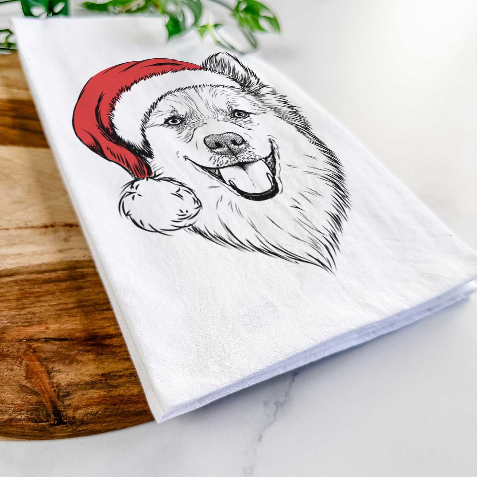 Hand-drawn sketch of Ari the Icelandic Sheepdog wearing a Santa hat on a tea towel