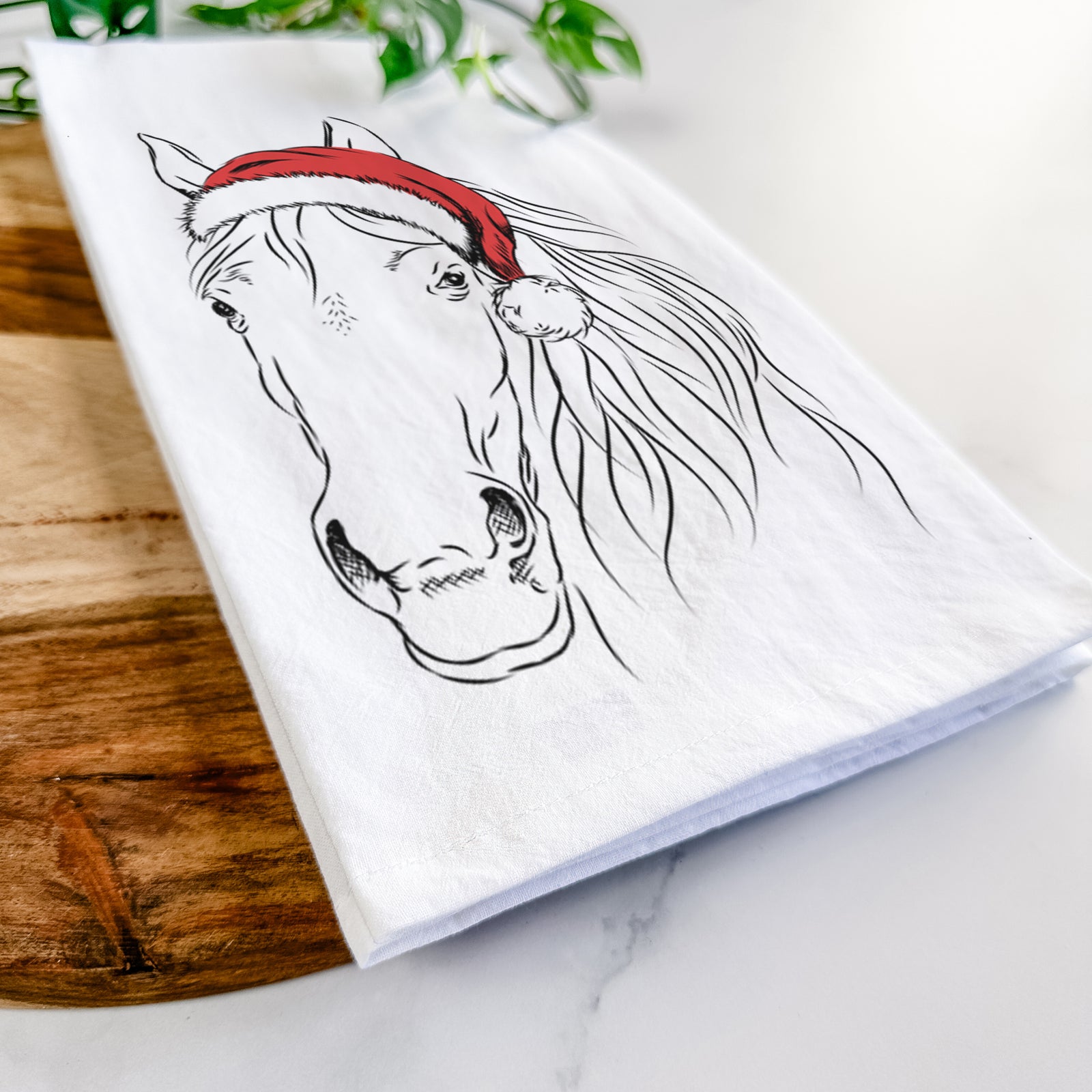 Hand-drawn sketch of Aria the Horse wearing a Santa hat on a tea towel
