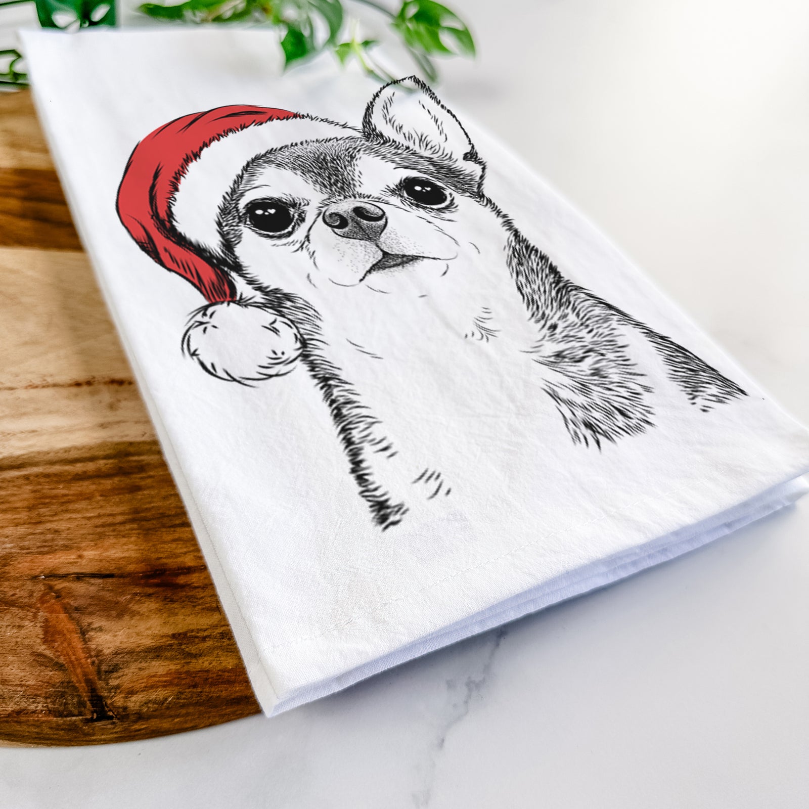 Hand-drawn sketch of Baby the Chihuahua wearing a Santa hat on a tea towel