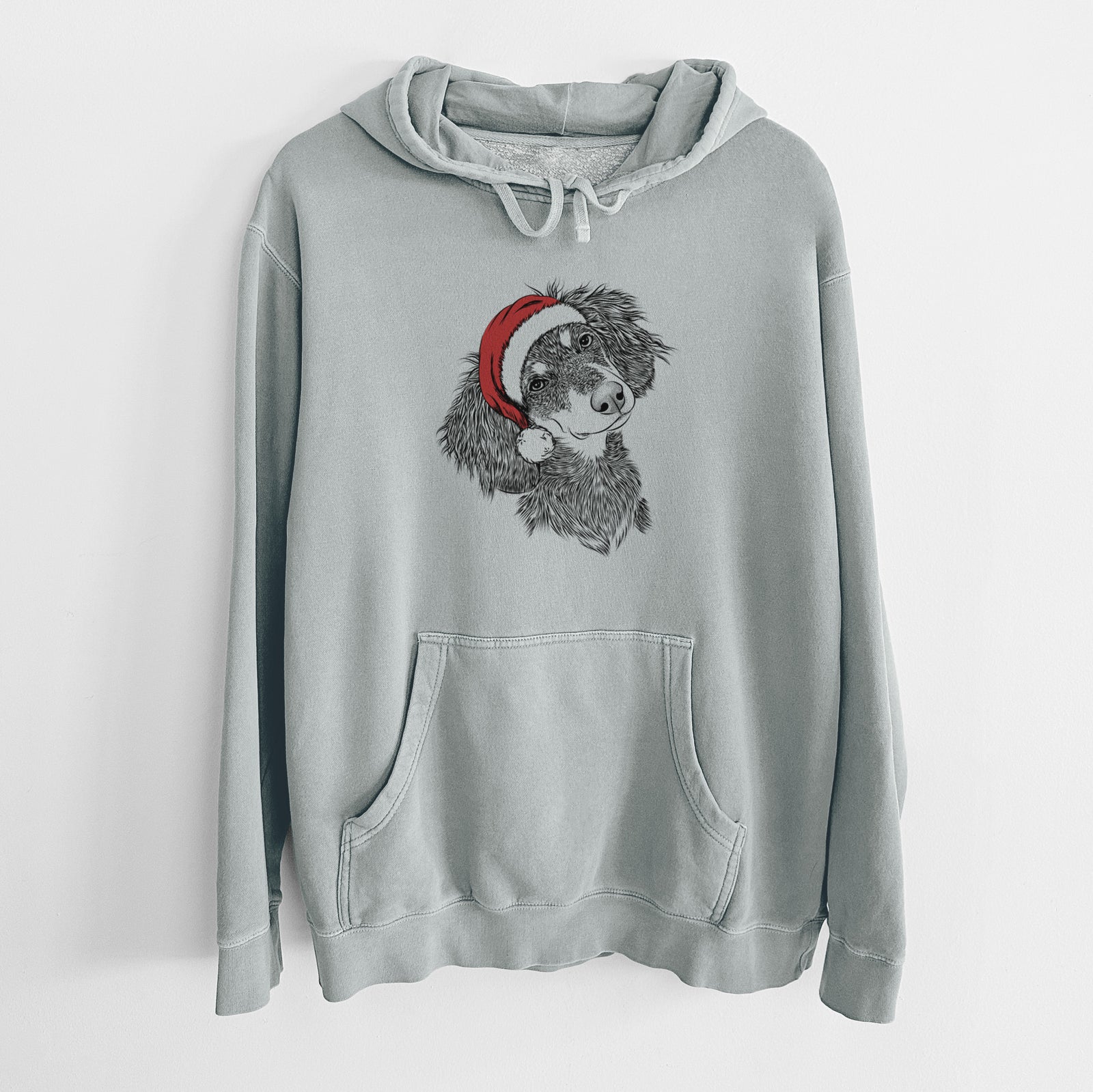 Hand-drawn sketch of Bailey the Long Haired Dachshund wearing a Santa hat on a Sage Unisex pigment dyed hoodie
