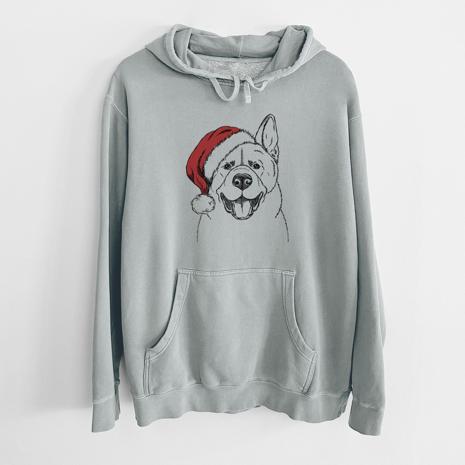 Hand-drawn sketch of Baku the Akita wearing a Santa hat on a Sage Unisex pigment dyed hoodie