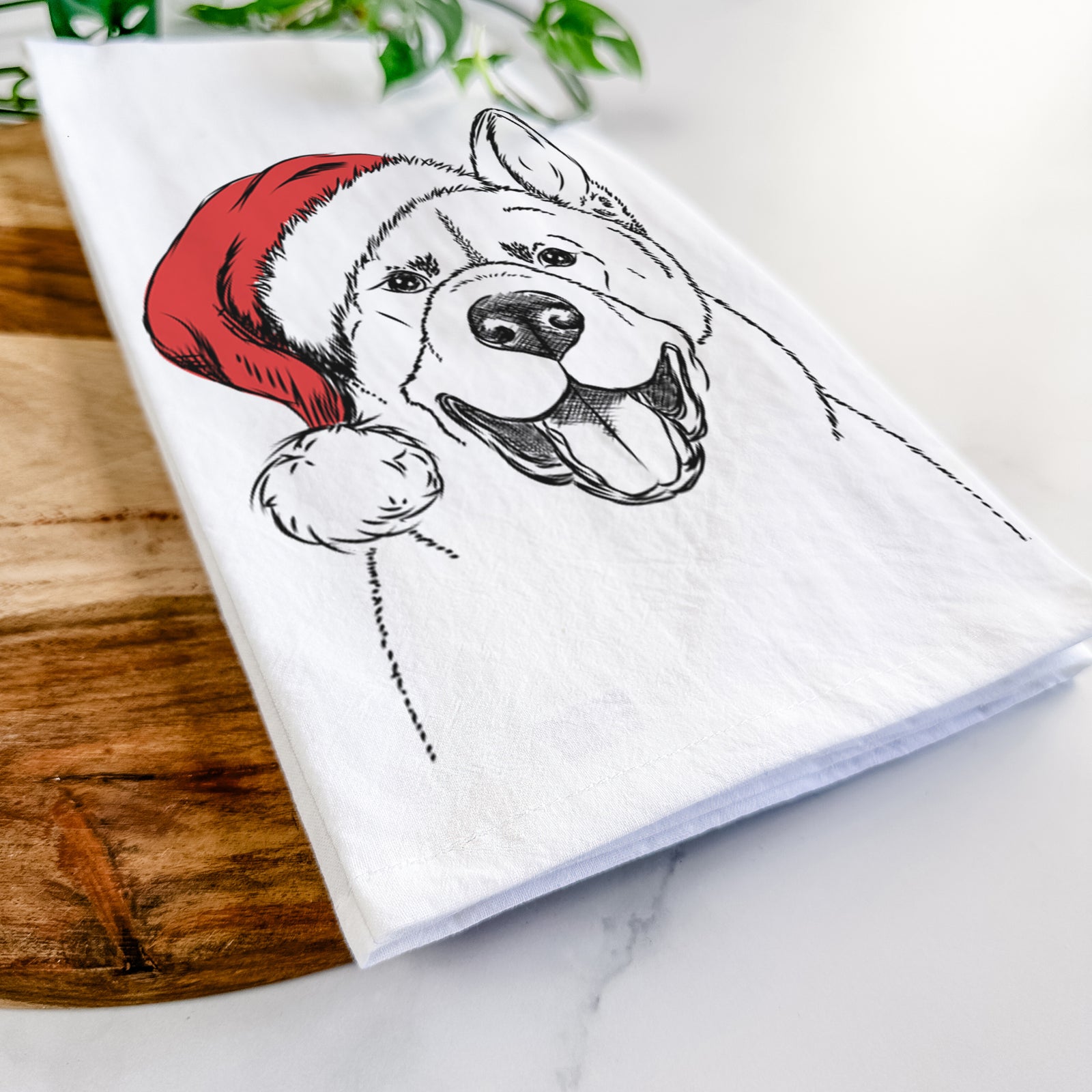 Hand-drawn sketch of Baku the Akita wearing a Santa hat on a tea towel