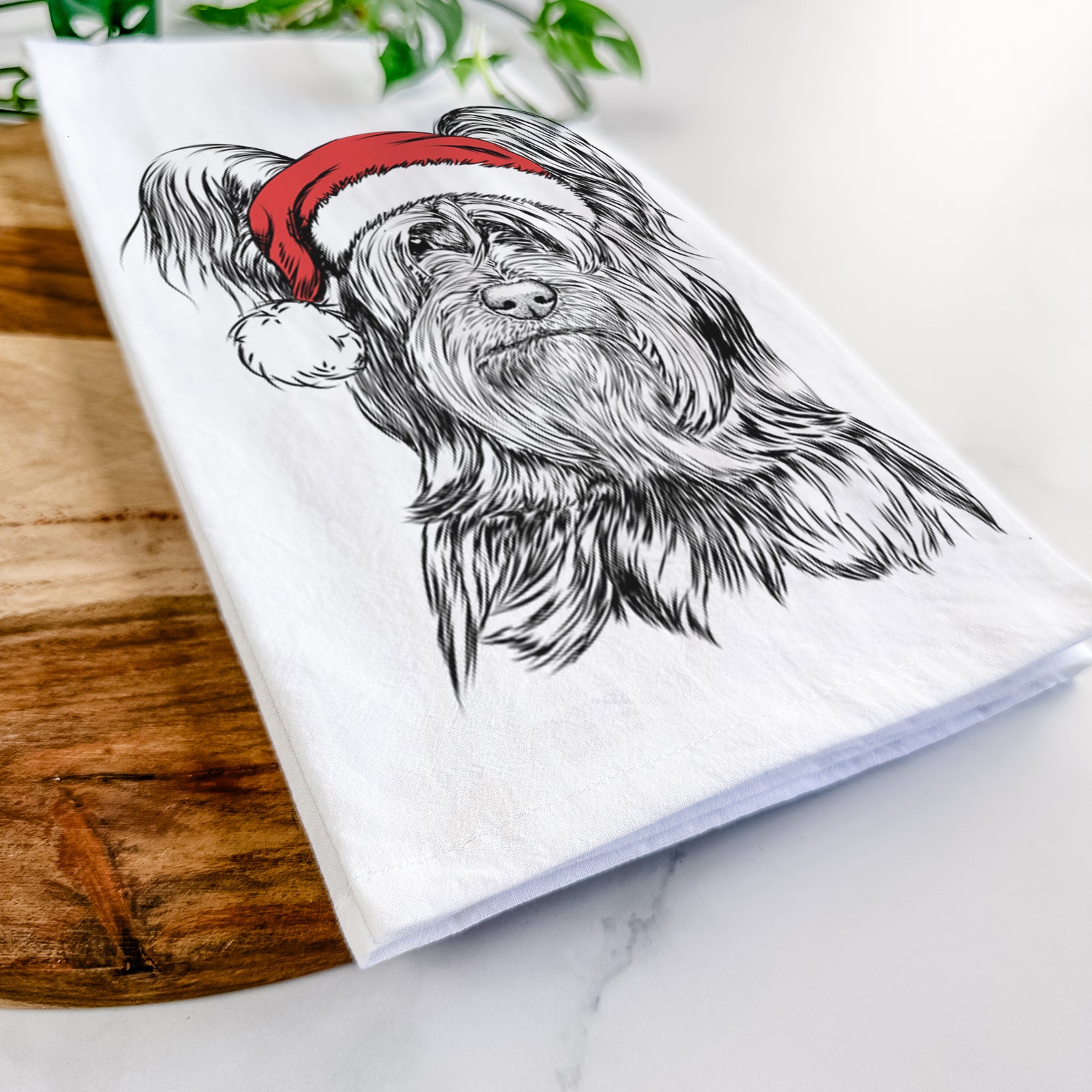 Hand-drawn sketch of Bandit the Skye Terrier wearing a Santa hat on a tea towel