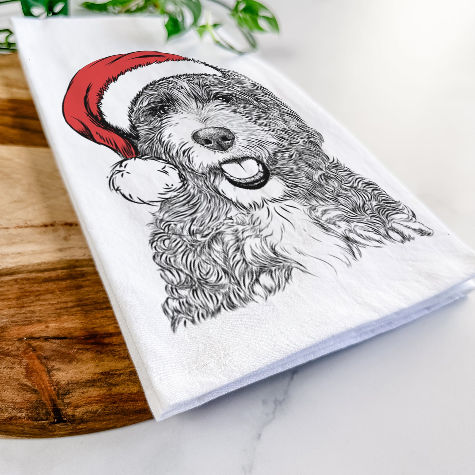 Hand-drawn sketch of Bash the Bernedoodle wearing a Santa hat on a tea towel
