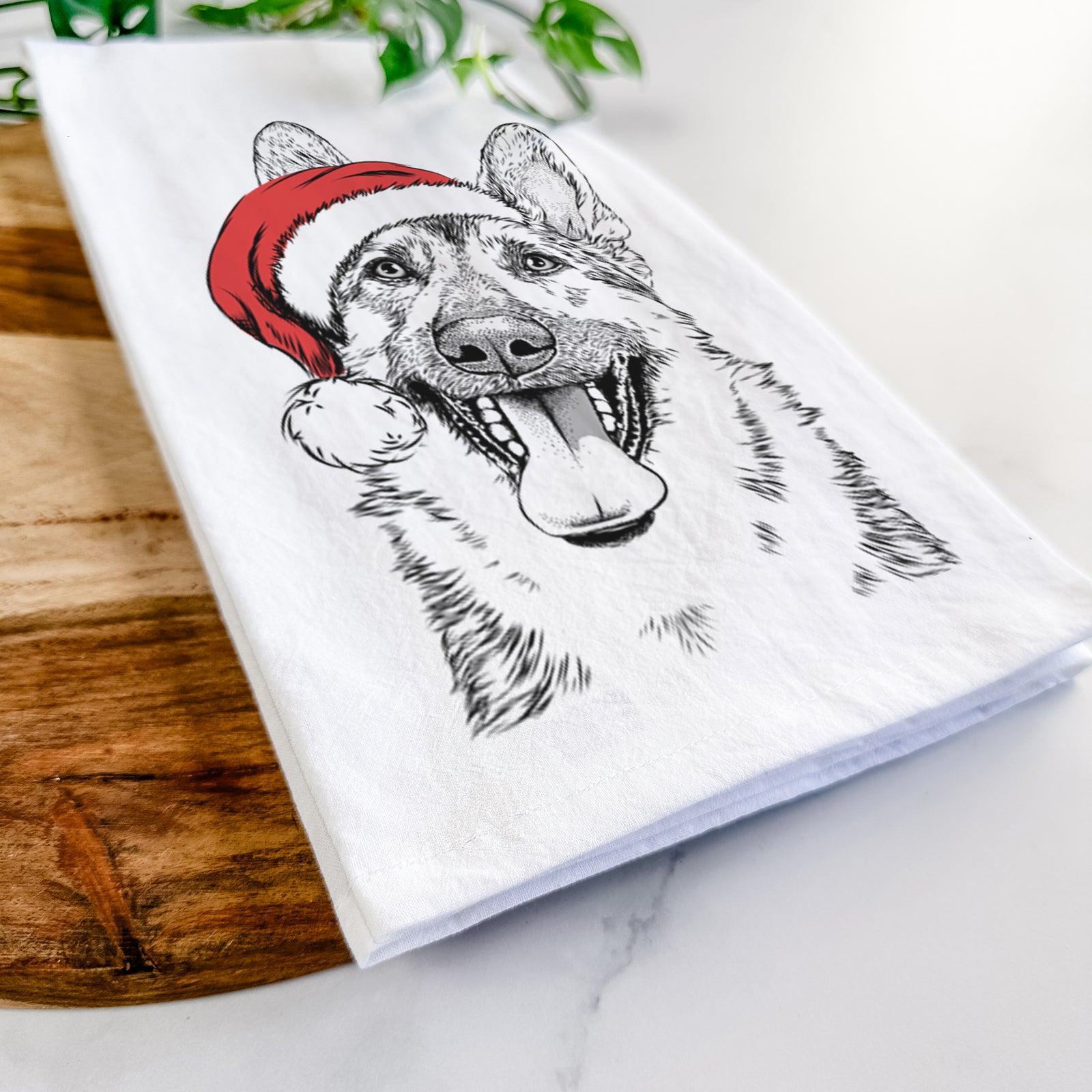 Hand-drawn sketch of Benson the German Shepherd wearing a Santa hat on a tea towel