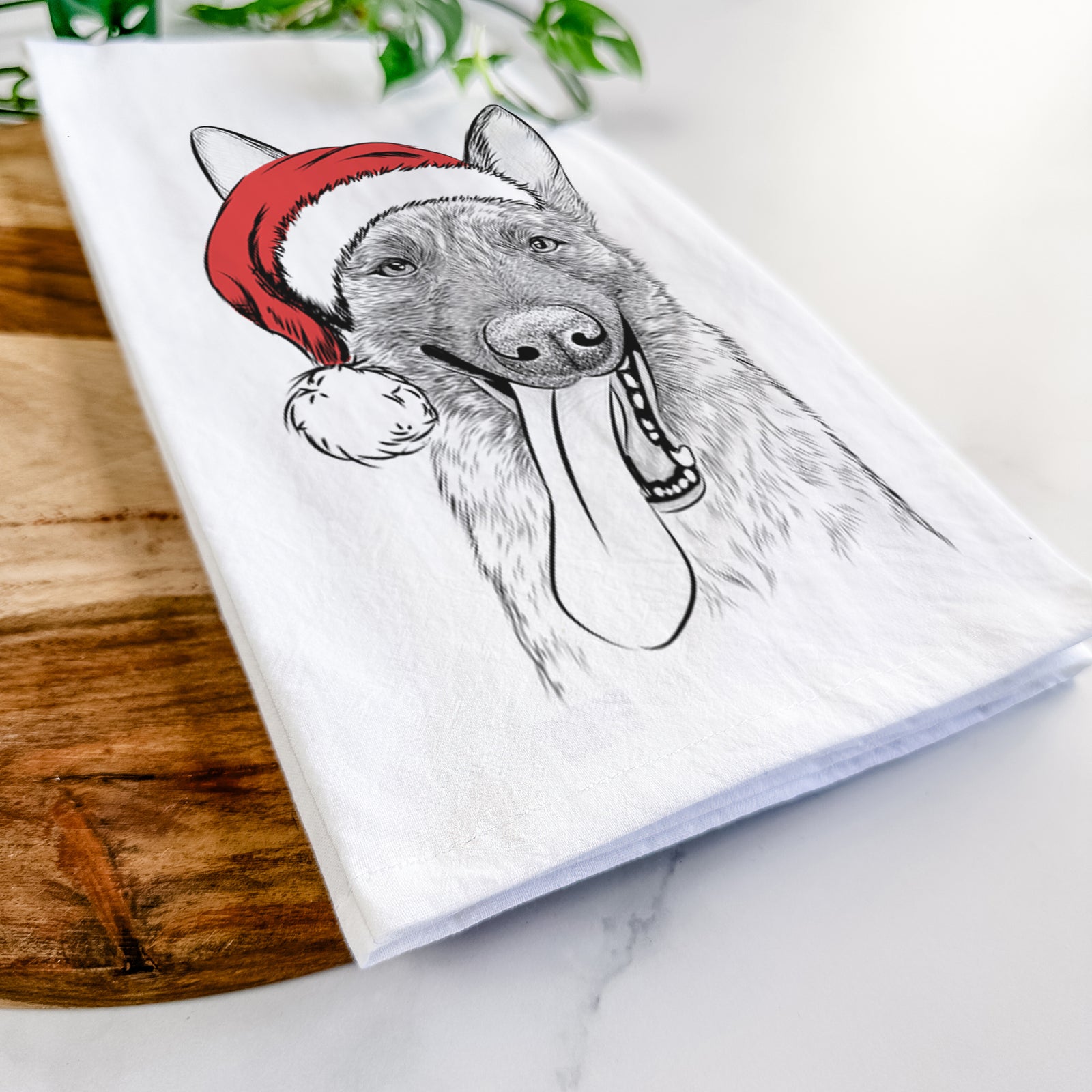 Hand-drawn sketch of Bessa the Dutch Shepherd wearing a Santa hat on a tea towel