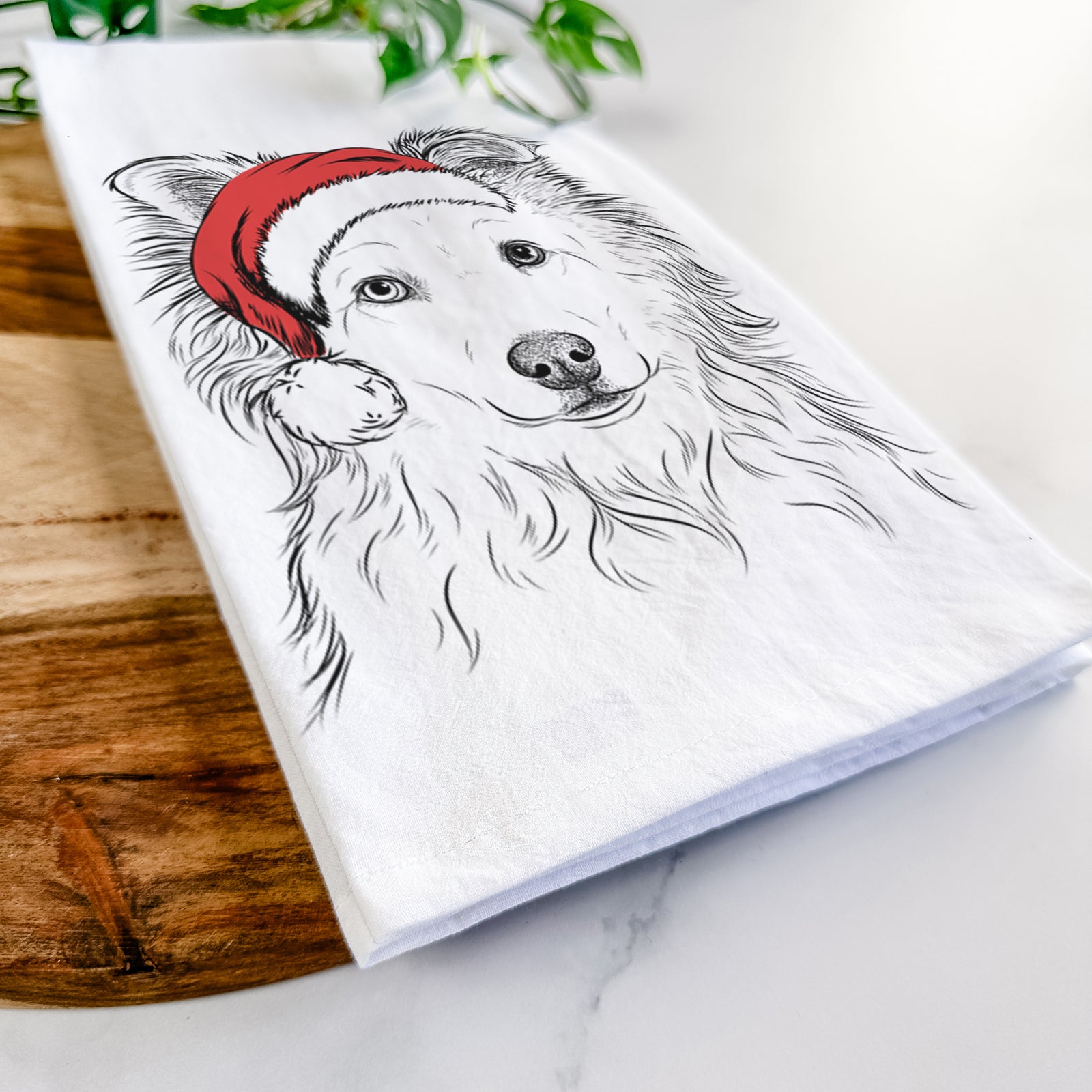 Hand-drawn sketch of Bonsai the Mixed Breed wearing a Santa hat on a tea towel
