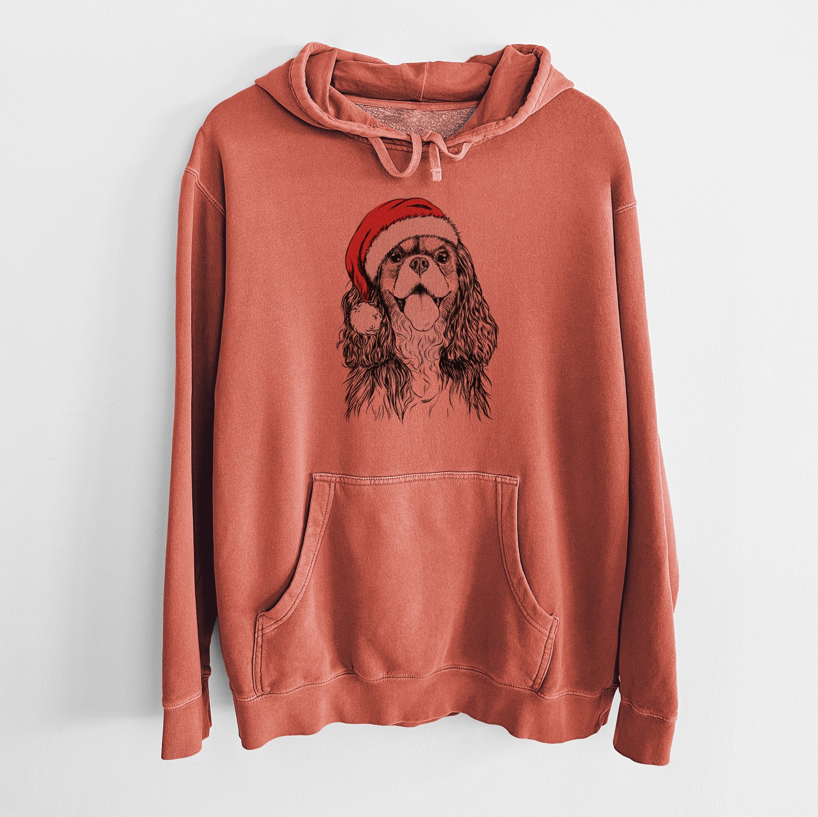 Hand-drawn sketch of Brandy the Cavalier King Charles Spaniel wearing a Santa hat on an Amber Unisex pigment dyed hoodie