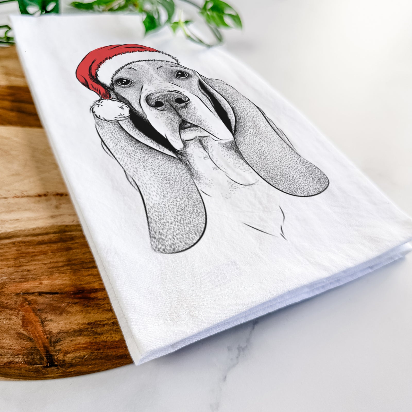 Hand-drawn sketch of Buckley the Basset Hound wearing a Santa hat on a tea towel