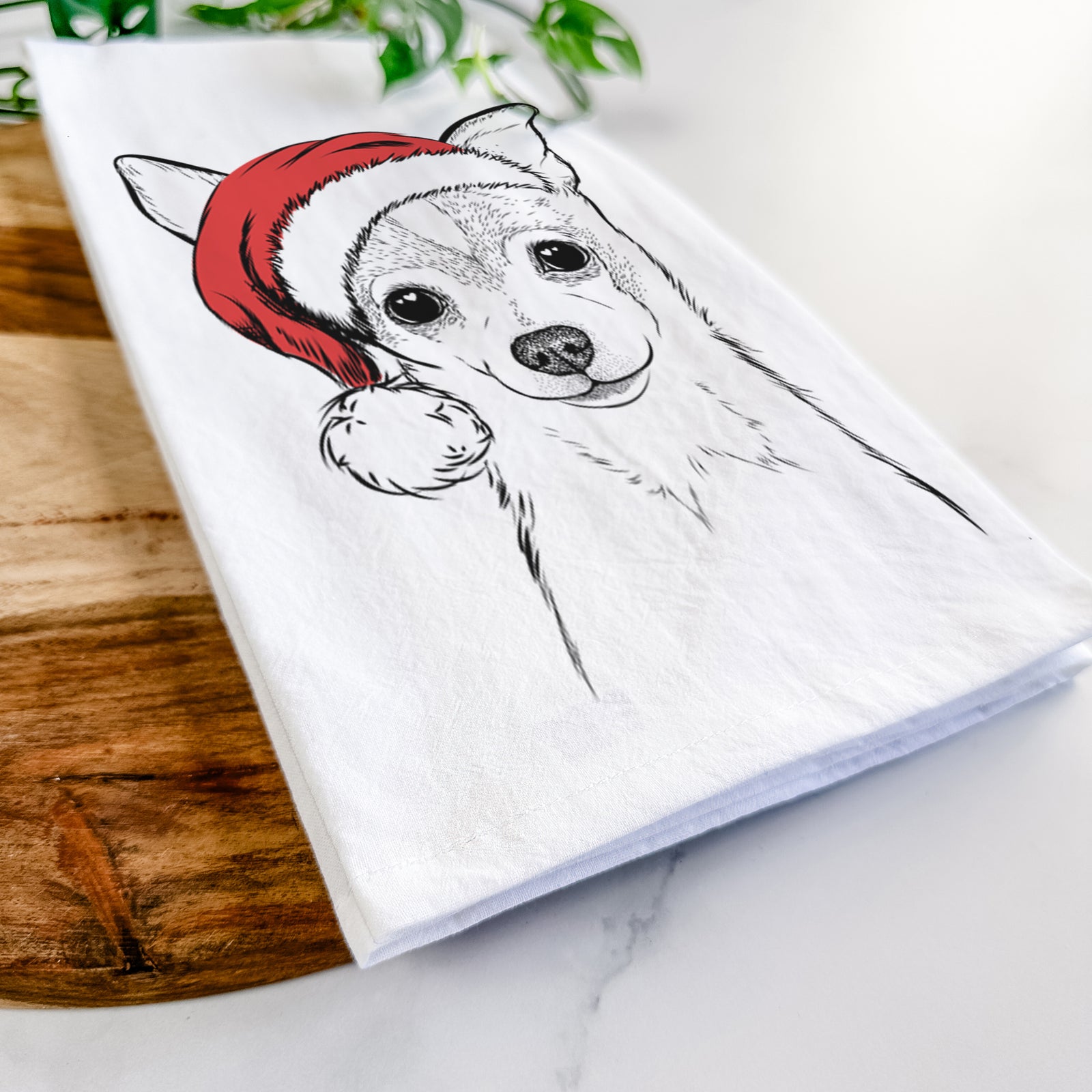 Hand-drawn sketch of Buggy the Chihuahua wearing a Santa hat on a tea towel