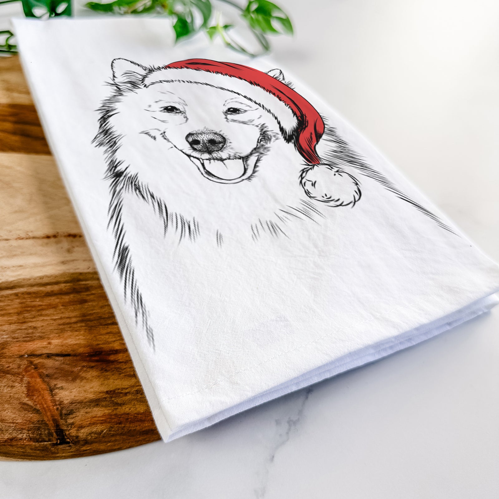 Hand-drawn sketch of Caico the Samoyed wearing a Santa hat on a tea towel