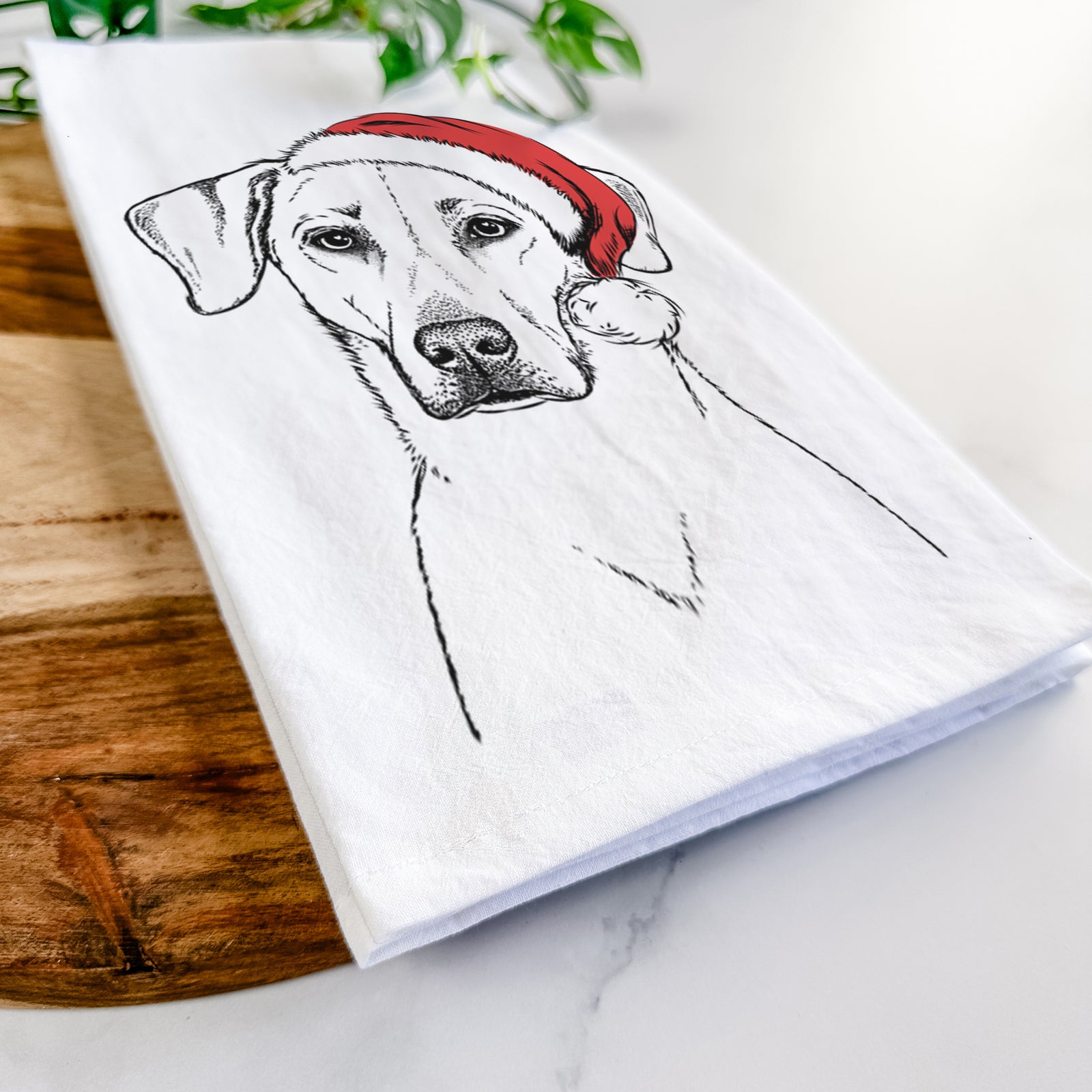 Hand-drawn sketch of Charlie Girl the Yellow Lab wearing a Santa hat on a tea towel