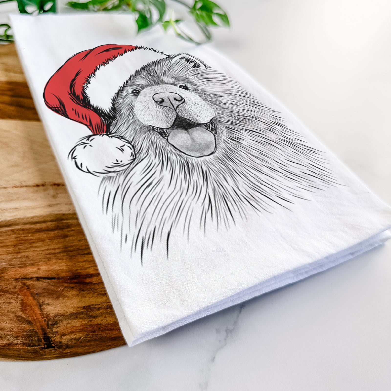 Hand-drawn sketch of Charming Charlie the Chow Chow wearing a Santa hat on a tea towel