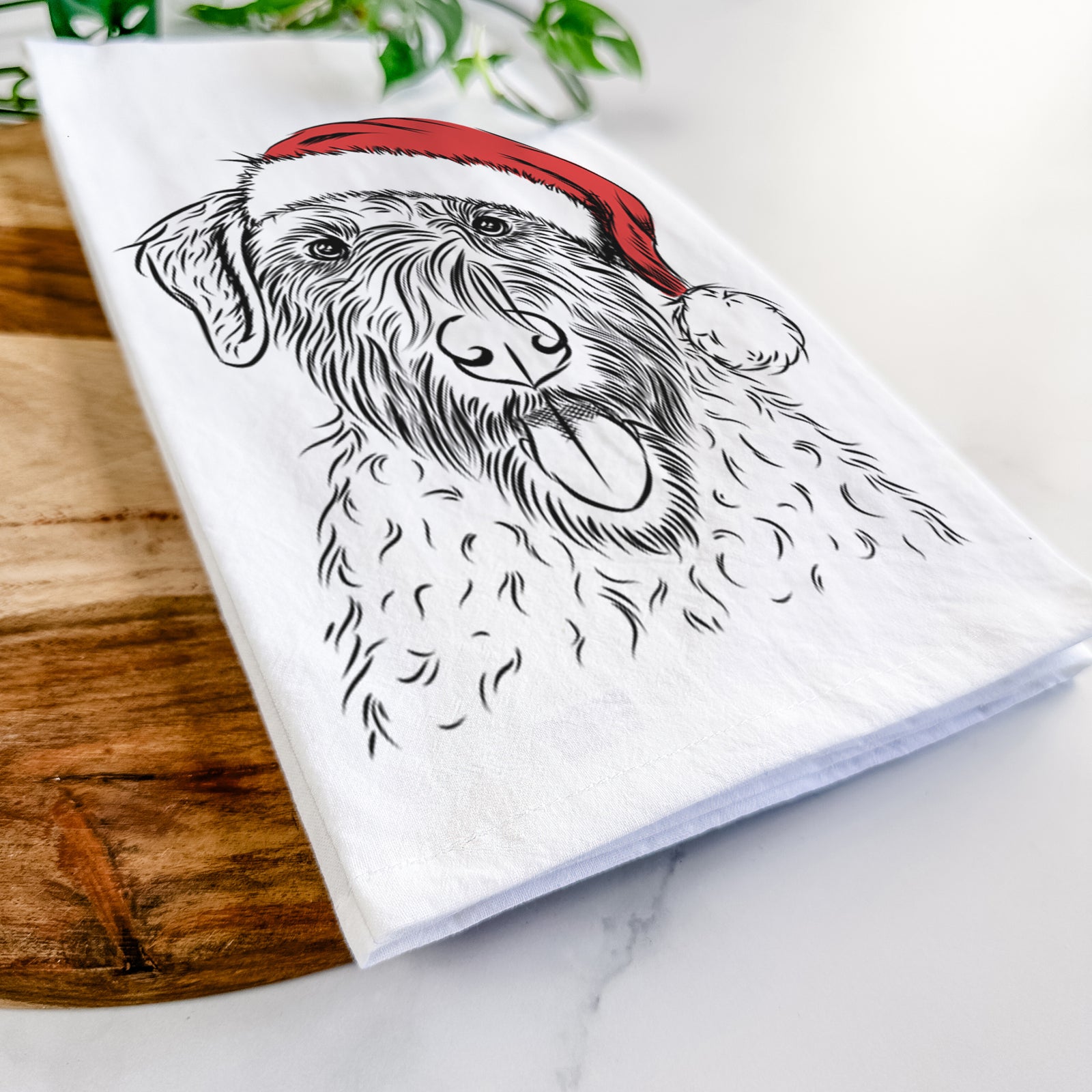 Hand-drawn sketch of Chester the Soft Coated Wheaten Terrier wearing a Santa hat on a tea towel