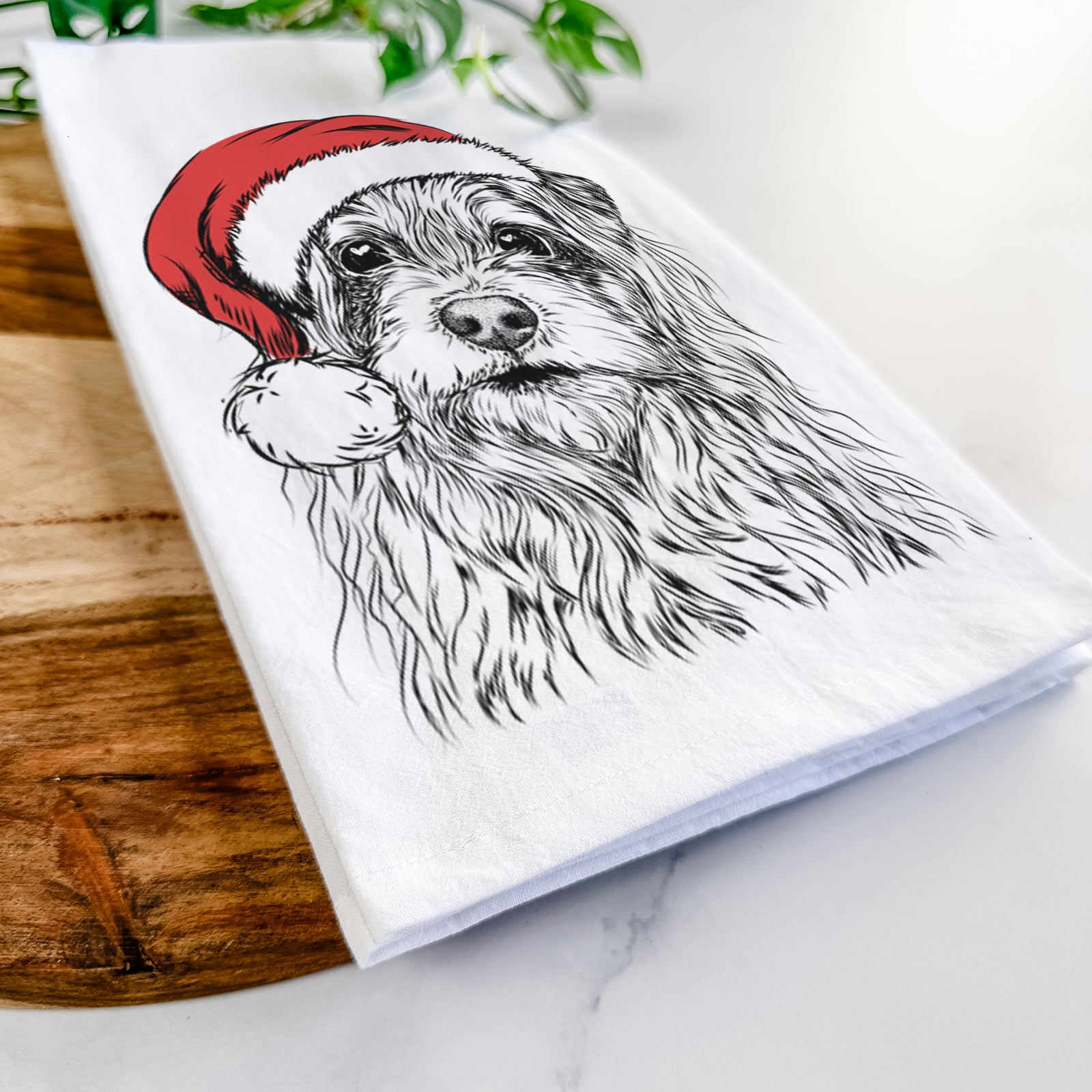 Hand-drawn sketch of Chester the Terrier Mix wearing a Santa hat on a tea towel