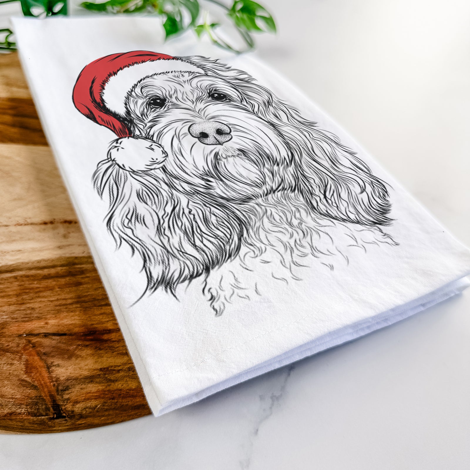 Hand-drawn sketch of Chloe the Cockapoo wearing a Santa hat on a tea towel