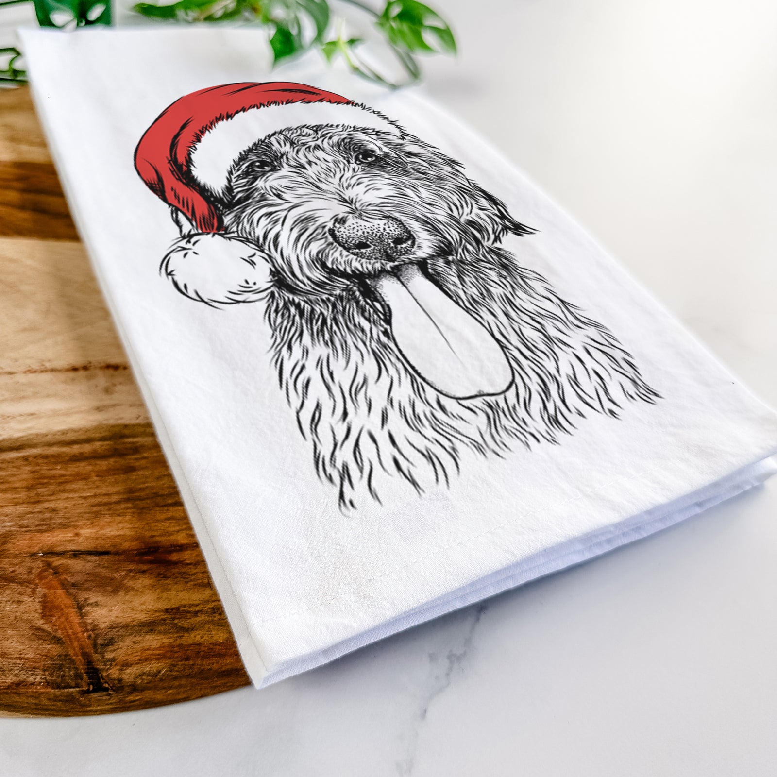 Hand-drawn sketch of CiCi Paulk the Aussiedoodle wearing a Santa hat on a tea towel