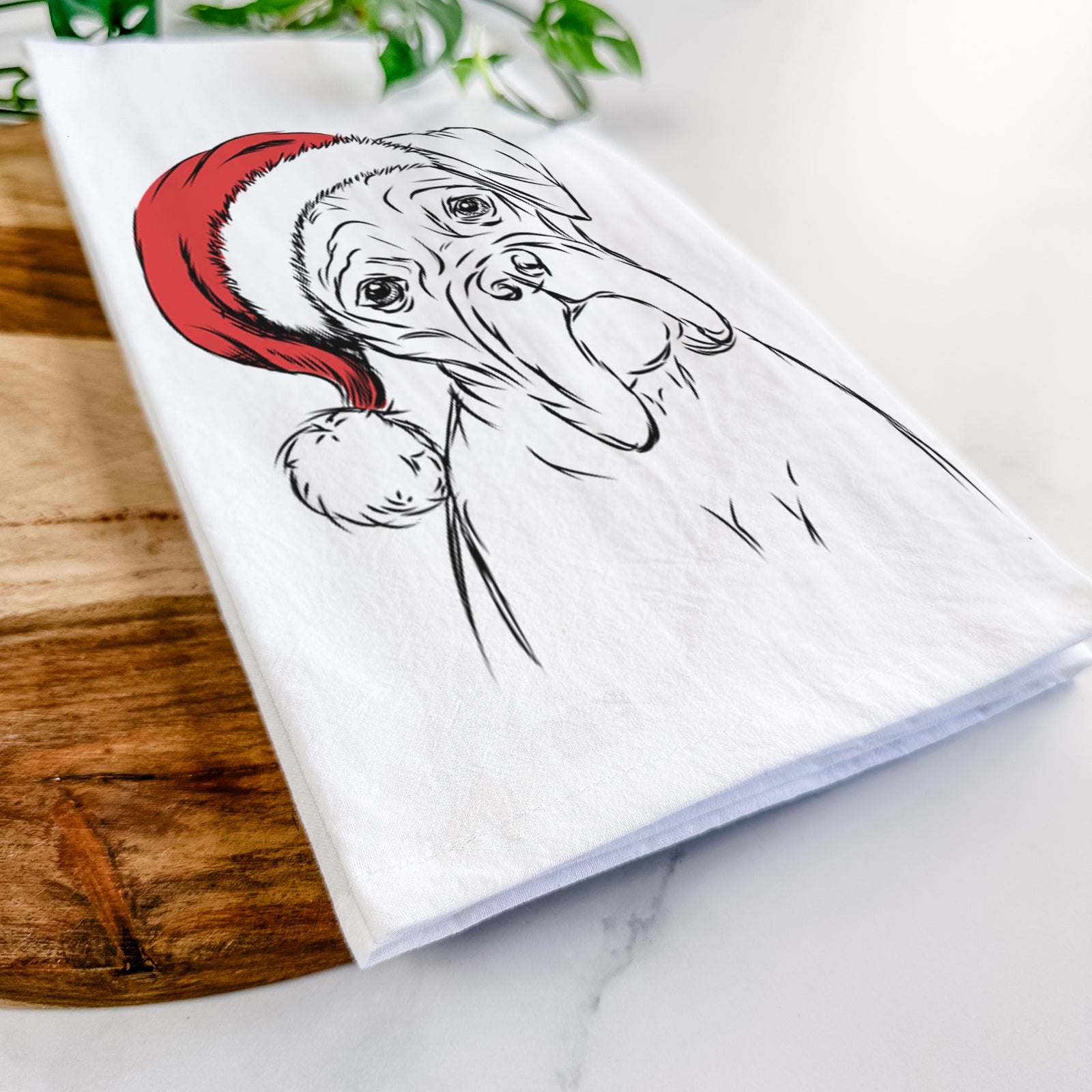 Hand-drawn sketch of Cooper the Boxer wearing a Santa hat on a tea towel