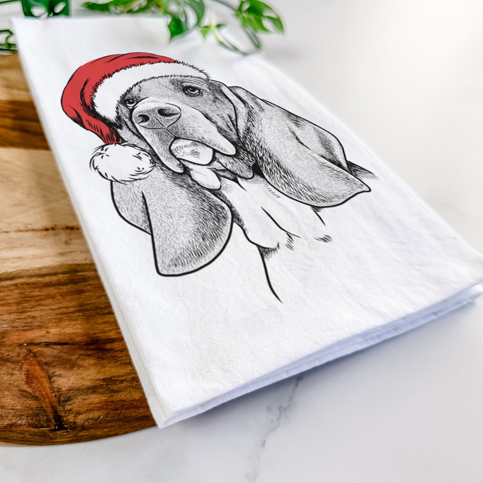 Hand-drawn sketch of Cooper the Basset Hound wearing a Santa hat on a tea towel